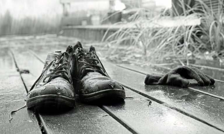 Abandoned Shoes in Rain on Wooden Deck