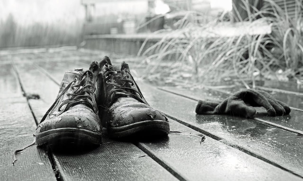 Abandoned Shoes in Rain on Wooden Deck