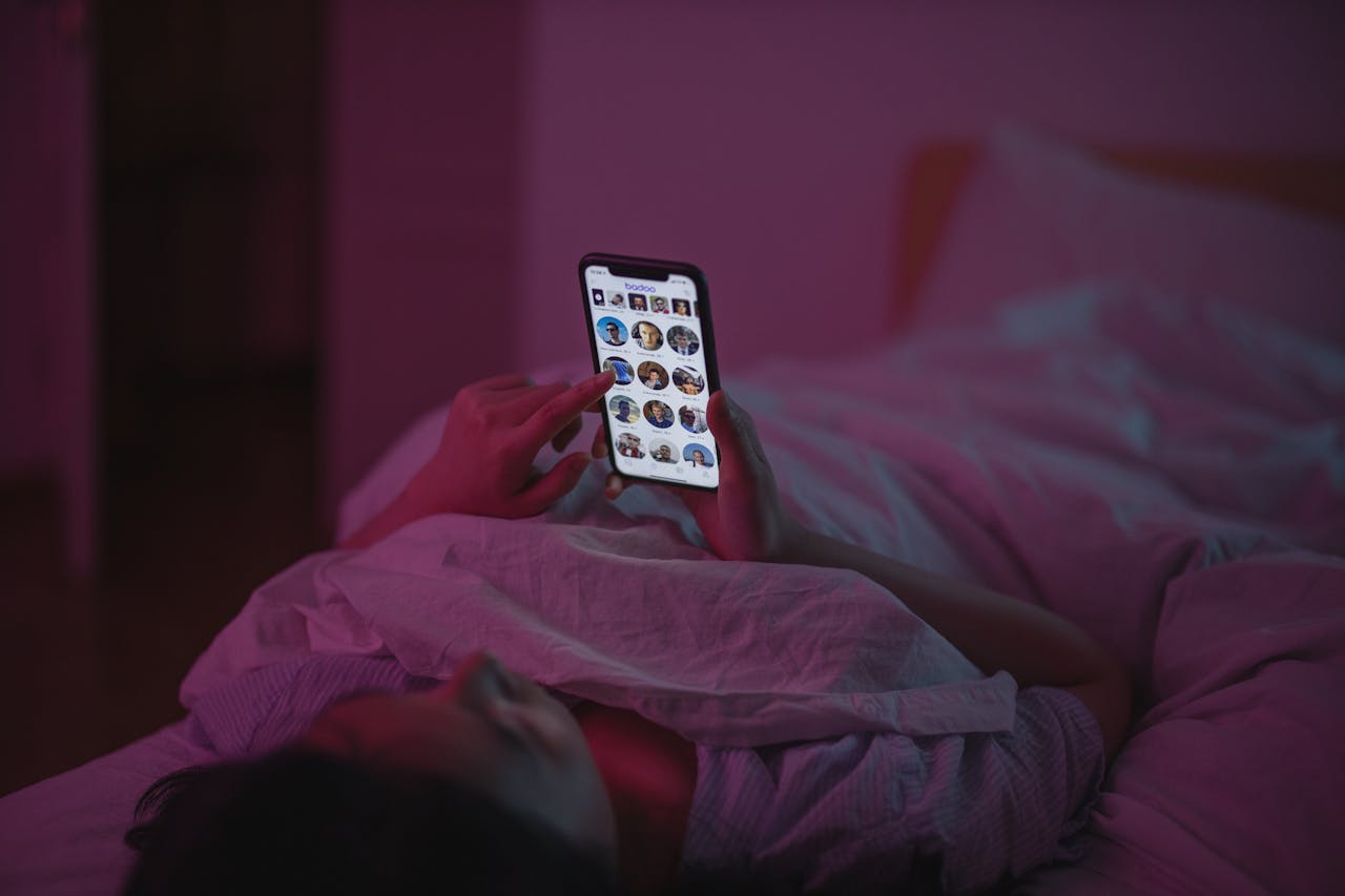 A Woman Lying on Bed while using Smartphone