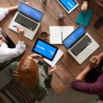 Top View Photo of Group of People Using Macbook While Discussing