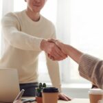 Man and Woman Handshake Near Table