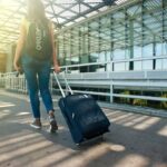 A women with his luggage walking.