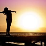 Women is relaxing infornt of rising sun