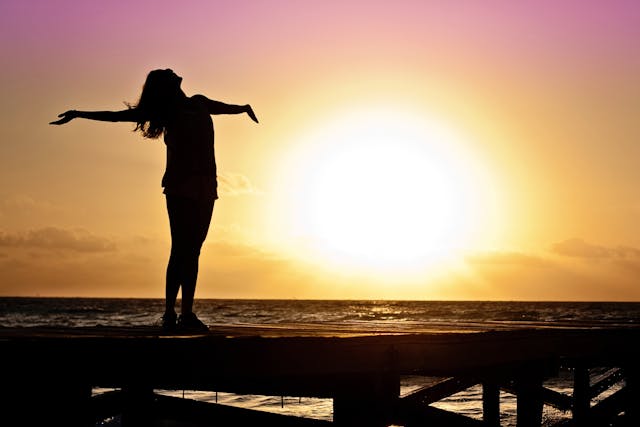 Women is relaxing infornt of rising sun