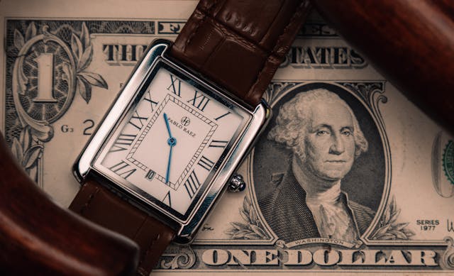 A watch in placed on a currency note.