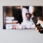 Person Pressing the Button of a Remote Control