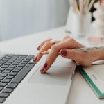 Person Using Laptop on White Table