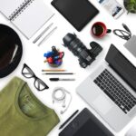 Different gadgets and a shirt and a pair of glasses.