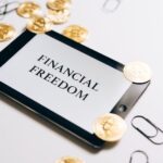 Financial freedom written on a white background with some coins side by side