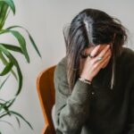 Worried young woman covering face with hand