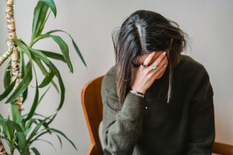 Worried young woman covering face with hand