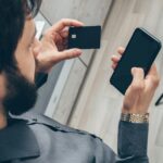 A man holding phone and credit card.