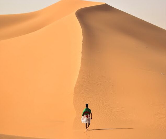 A man is walking on sand mountain