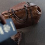 A man is Traveling while showing his passport and a bag.