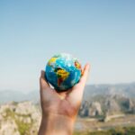 A world map globe in hand of a man.