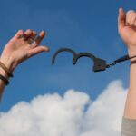 Man with open handcuff hand in the air