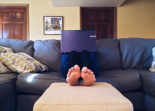 A man using laptop on a couch.