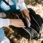 Person Putting a Booking Inside a Backpack