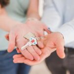 A home key giving with hands of two people to someone