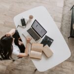 Young lady using laptop at table in modern workspace