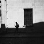 Silhouette of Woman Walking Along French Street