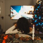 Woman Watching TV in Living Room at Christmas Time