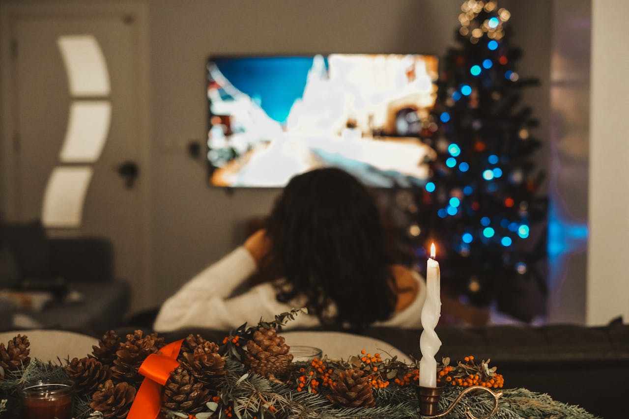 Woman Watching TV in Living Room at Christmas Time