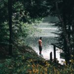 A Topless Man Standing Beside the Lake