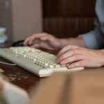 A Person's Hands Typing on a Keyboard