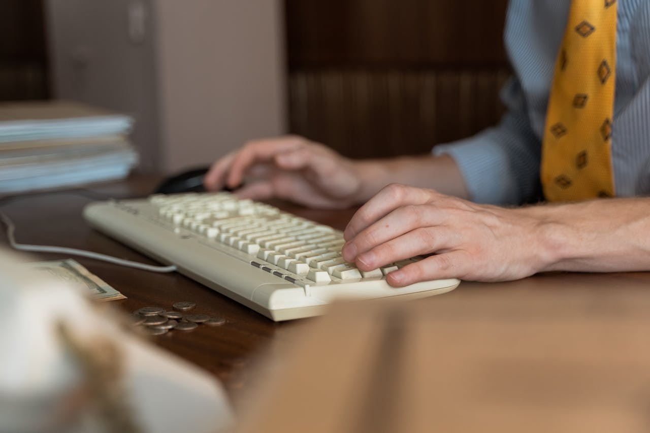 A Person's Hands Typing on a Keyboard