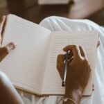 A Person Writing on a Notebook