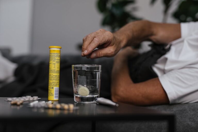 Person Putting Medicine on the Glass of Water