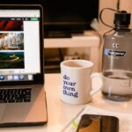 White Ceramic Mug Beside Macbook Pro