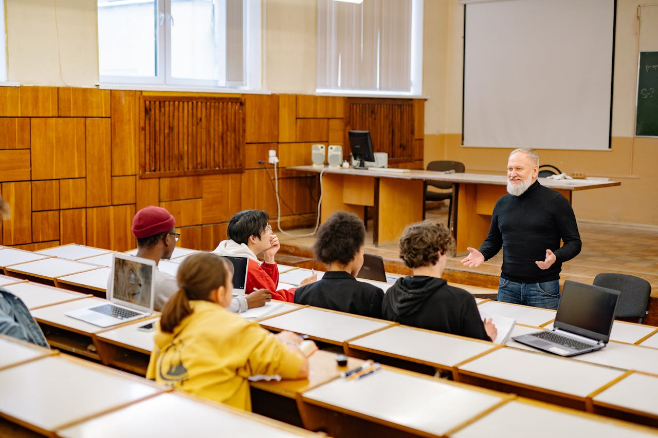 Students using tablets and laptops in a classroom, representing the impact of tech companies on education.